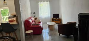 a living room with a red chair and a television at Maison d' Adèlbraz in Voulaines
