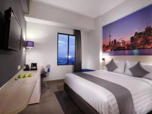 a hotel room with a large bed and a window at StarRay Hotel Jakarta Kebayoran in Jakarta