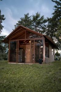 a small house with glass doors on the grass at Las Cabañas La Libertad in Macanal