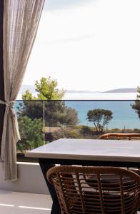 a table and two chairs in front of a window at Alkida Luxury Rooms Tolo in Tolo