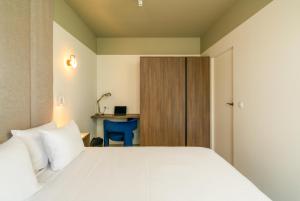 a bedroom with a white bed and a desk at apartamenty-wroc Central Park in Wrocław