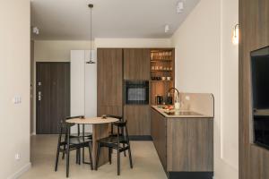 a kitchen with a table and chairs and a counter at apartamenty-wroc Central Park in Wrocław