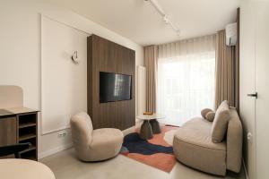 a living room with two chairs and a television at apartamenty-wroc Central Park in Wrocław