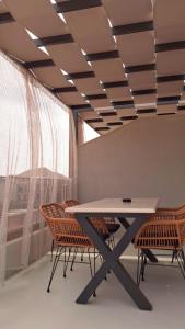 a table and chairs in a room with a window at Alkida Luxury Rooms Tolo in Tolo