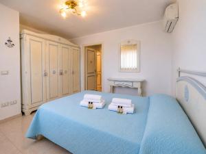 a bedroom with a blue bed with towels on it at B&W Sea View Two Bedroom Apartment with Pool Near the Beach in Baja Sardinia +10 photos