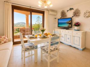 a living room with a table and a tv at B&W Sea View Two Bedroom Apartment with Pool Near the Beach in Baja Sardinia