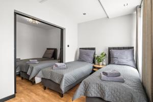 a bedroom with two beds and a large mirror at Central Platinum Apartments 13 in Rybnik