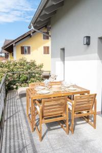 a wooden table and chairs on a balcony at Eggstätt am Chiemsee, Auto-Check-in 24-7, gratis Parkplatz an der Unterkunft, Netflix & Amazon Prime inc, voll ausgestattet in Eggstätt