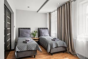 a bedroom with two beds and a window at Central Platinum Apartments 13 in Rybnik