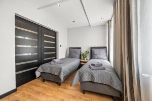 a bedroom with two twin beds and a table at Central Platinum Apartments 13 in Rybnik