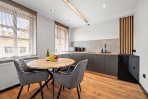 a kitchen with a wooden table and chairs in a kitchen at Central Platinum Apartments 13 in Rybnik +20 photos