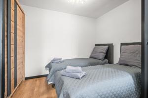 a bedroom with two twin beds and a chandelier at Central Platinum Apartments 13 in Rybnik