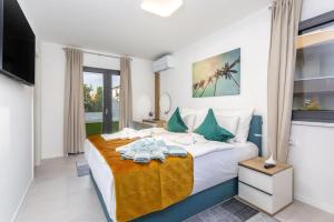 a bedroom with a large white bed with green pillows at Apartments Luna in Malinska +22 photos