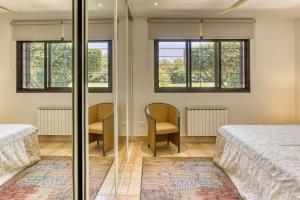 a bedroom with two beds and two chairs at Villa Greta in Navata +30 photos