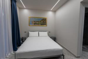 a white bed in a room with blue curtains at Retrait Lake Como Private Design Retreat with Lake View in Perledo