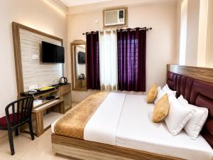 a hotel room with a bed and a desk at Hotel City Palace in Varanasi