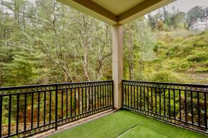 a balcony with a view of the woods at The Woodlane Cottage in Kūfrī