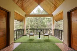 a large screened porch with a table and two chairs at The Woodlane Cottage in Kūfrī