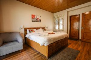 a bedroom with a large bed and a couch at The Woodlane Cottage in Kūfrī