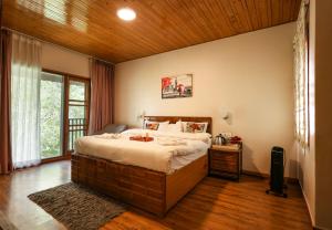 a bedroom with a large bed with a wooden ceiling at The Woodlane Cottage in Kūfrī