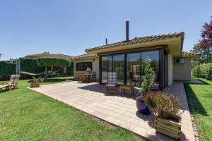 a garden with a patio and a house at Villa Greta in Navata