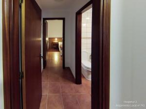 a hallway of a bathroom with a toilet and a sink at Hospetur 2 in Horta