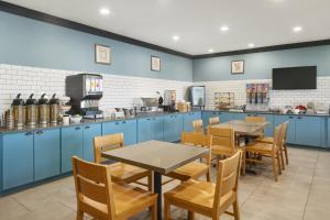 a restaurant with blue cabinets and tables and chairs at Country Inn & Suites by Radisson, Manteno, IL in Manteno