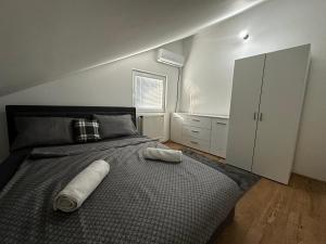 a bedroom with a bed with two towels on it at Stan na dan in Obrenovac