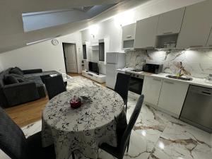 a kitchen and living room with a table and chairs at Stan na dan in Obrenovac
