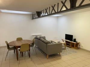 a living room with a couch and a table at Eiffel in Haubourdin