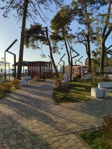 a walkway with benches and trees in a park at "Ламази"Домашняя гостиница in Kobuleti