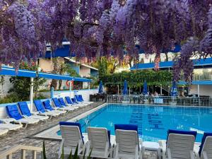 a swimming pool with chairs and purple flowers hanging over it at Side Temple Hotel in Side