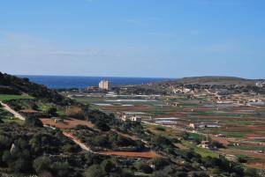 una vista de una ciudad con el océano en el fondo en Secco's Seaview Accommodation en Mġarr