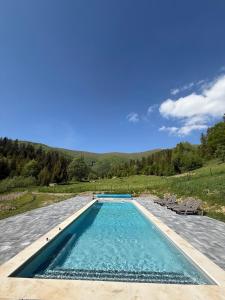 a swimming pool with chairs and a blue sky at Domik v gorakh in Bukovets
