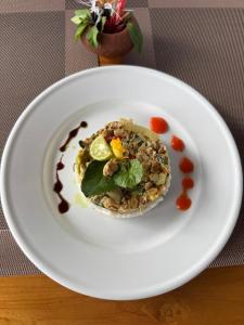 a white plate with a food dish on a table at Gauri Villas Sidemen in Sidemen