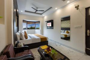 a hotel room with a bed and a couch at Hotel Dharam Villa By Jai Guru Ji At Sector 11, Noida in Noida