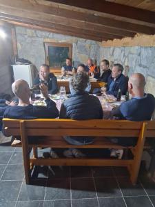 a group of men sitting around a wooden table at Katun Senic in Berane