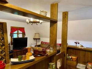 a living room with a table with a television at Casa dintre Brazi Colibita in Colibiţa