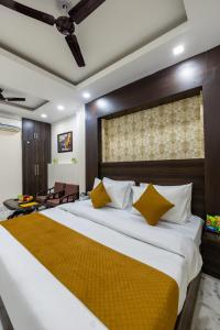 a bedroom with a large bed with yellow pillows at Hotel Dharam Villa By Jai Guru Ji At Sector 11, Noida in Noida +50 photos