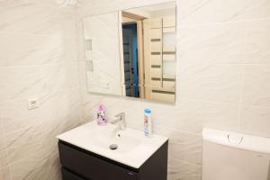 a bathroom with a sink and a mirror at AMA Residence Premium Apartment in Târgu-Mureş +40 photos