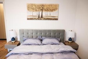 a bedroom with a bed and two night stands with lamps at AMA Residence Premium Apartment in Târgu-Mureş