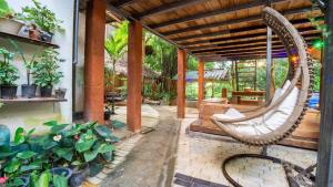 a porch with a swinging hammock in a garden at Sigiriya River Side Villa in Sigiriya