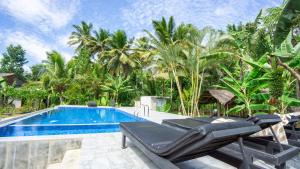 a villa with a swimming pool and palm trees at Sigiriya River Side Villa in Sigiriya