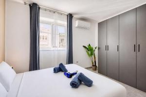 a bedroom with a white bed with blue shoes on it at Modern Maisonette with Valley Views KARP1-3 in San Ġwann