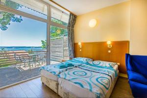 a bedroom with a bed and a large window at Maestral Residence in Portorož