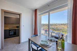 a dining room with a table and a large window at Modern Maisonette with Valley Views KARP1-3 in San Ġwann