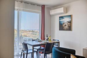 a dining room with a table and chairs and a window at Modern Maisonette with Valley Views KARP1-3 in San Ġwann +15 photos