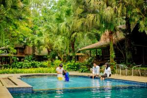 a group of people standing around a swimming pool at Katumbiri Resort and Villa by Tripletree in Bogor
