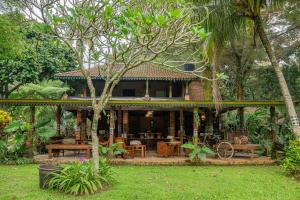 a house in the middle of a garden at Katumbiri Resort and Villa by Tripletree in Bogor +52 photos