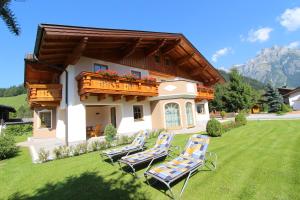 een groep stoelen op een gazon voor een huis bij Familie Meilinger - Werfenweng Ferienappartements in Werfenweng +33 foto's